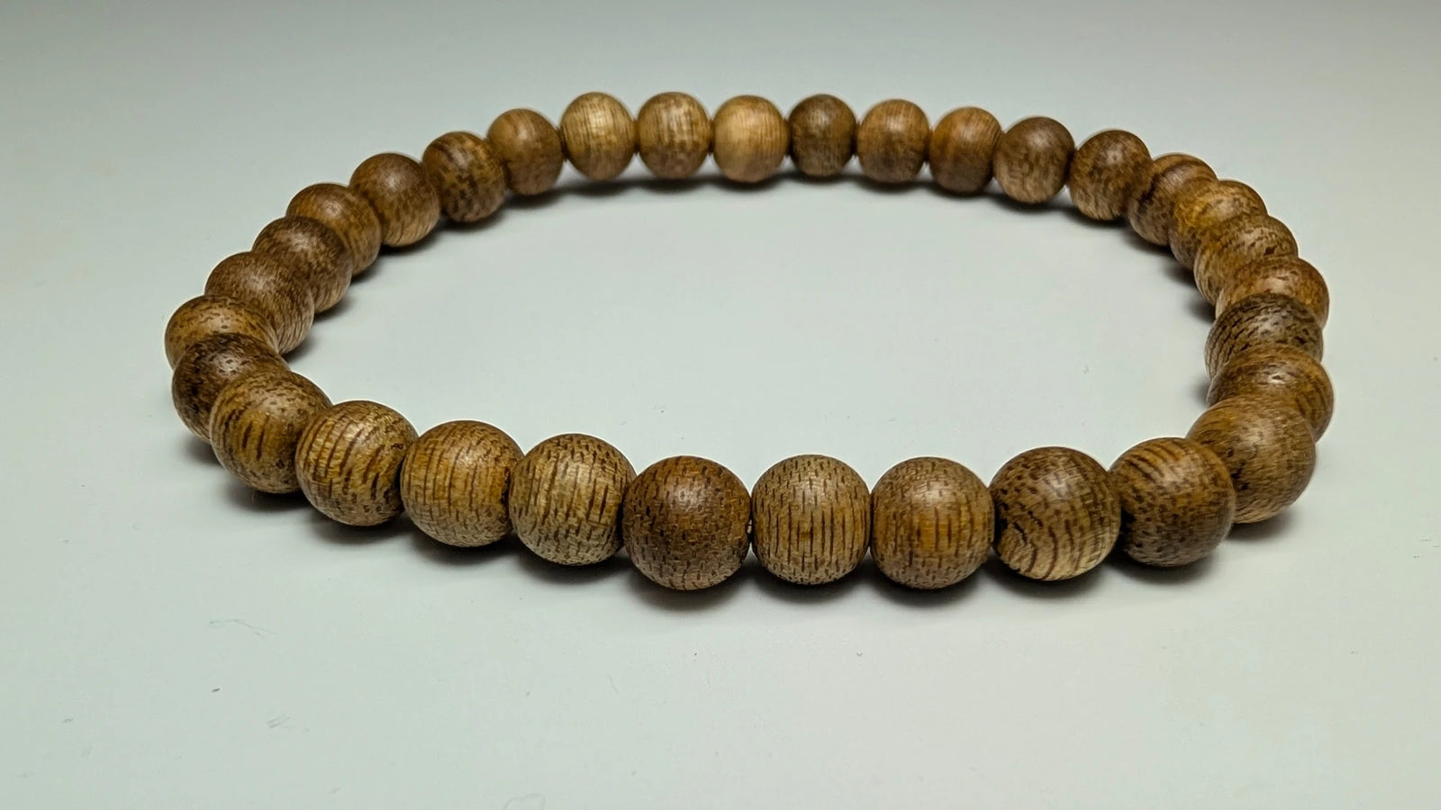 Wooden beaded bracelet on a light gray background